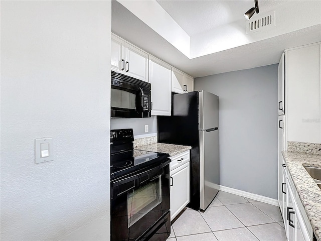 kitchen featuring light stone counters, white cabinetry, light tile patterned floors, and black appliances