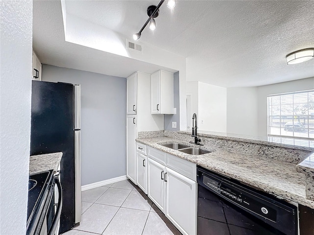 kitchen with sink, light stone counters, light tile patterned floors, stainless steel appliances, and white cabinets