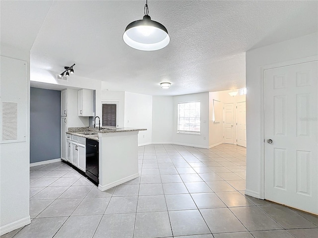 kitchen featuring dishwasher, light stone countertops, light tile patterned floors, and kitchen peninsula