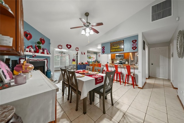 tiled dining area with lofted ceiling and ceiling fan