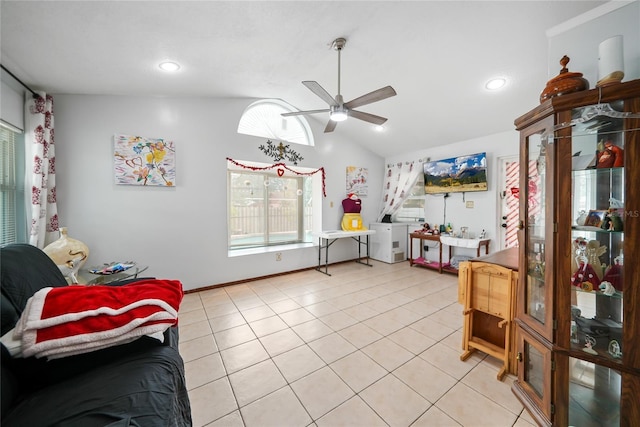 living area with ceiling fan, vaulted ceiling, and light tile patterned floors