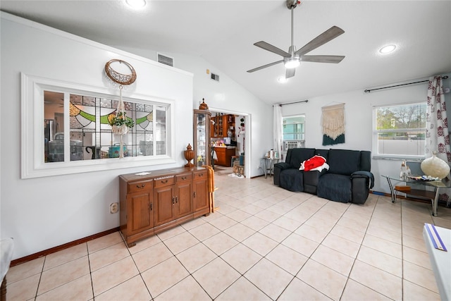 living room featuring ceiling fan, lofted ceiling, a wealth of natural light, and light tile patterned floors