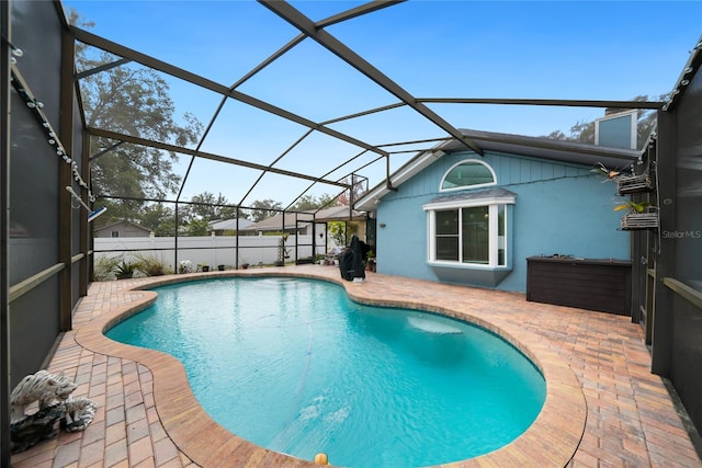 view of swimming pool featuring a patio and glass enclosure