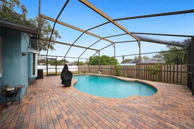 view of swimming pool with glass enclosure and a patio area