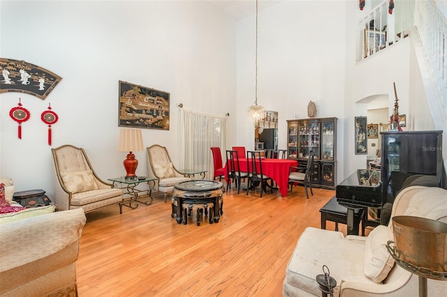 living room with hardwood / wood-style floors and a towering ceiling