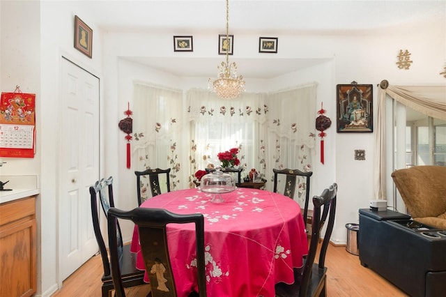 dining area with an inviting chandelier and light wood-type flooring