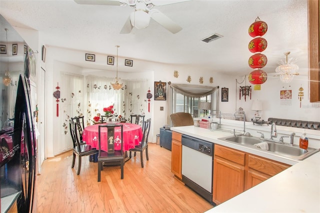 kitchen with sink, hanging light fixtures, white dishwasher, light hardwood / wood-style floors, and a textured ceiling