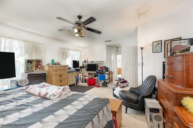 carpeted bedroom featuring ceiling fan and a textured ceiling