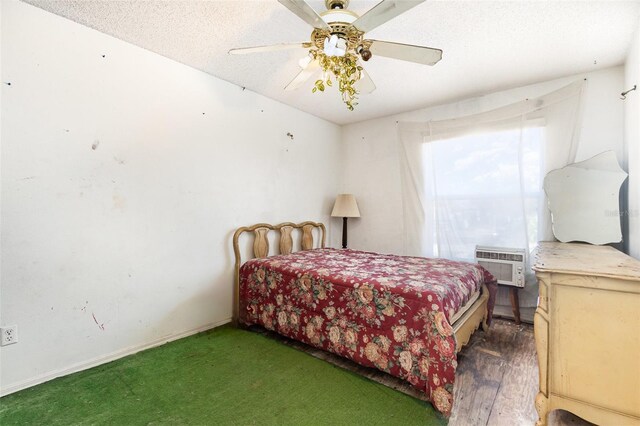 bedroom with ceiling fan, a textured ceiling, and a wall mounted AC