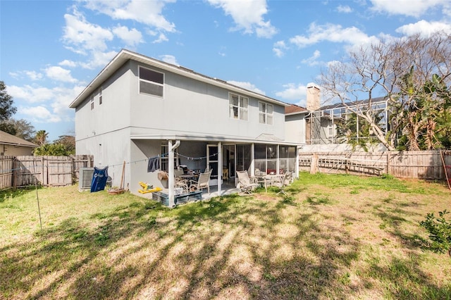 rear view of property with a yard, a patio, a sunroom, and central air condition unit