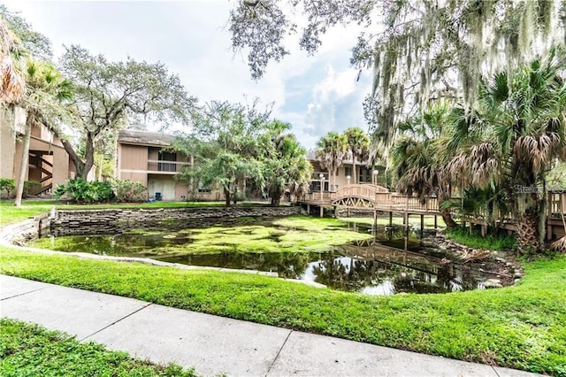 view of home's community featuring a water view and a yard