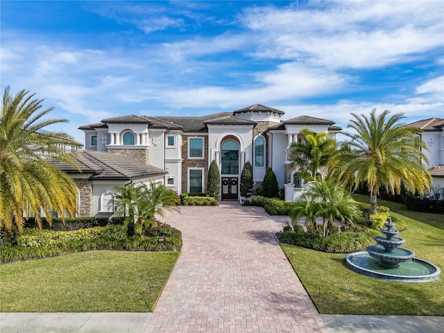 mediterranean / spanish home featuring a front yard