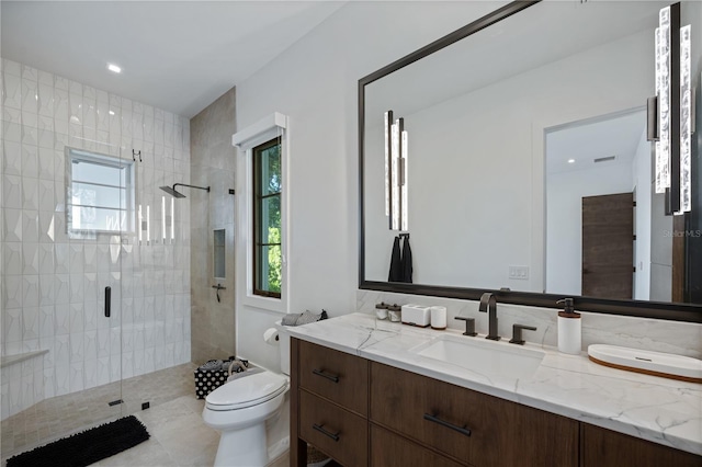 bathroom with a healthy amount of sunlight, vanity, toilet, and a shower with door