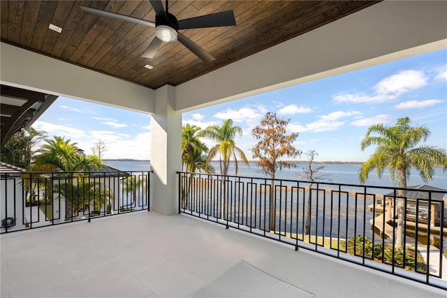 balcony featuring a water view and ceiling fan