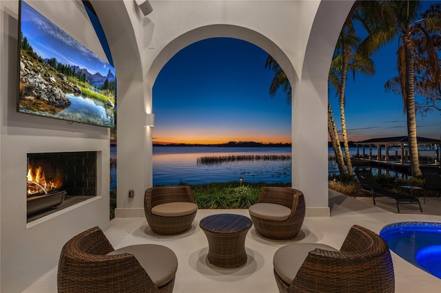 patio terrace at dusk featuring an outdoor fireplace