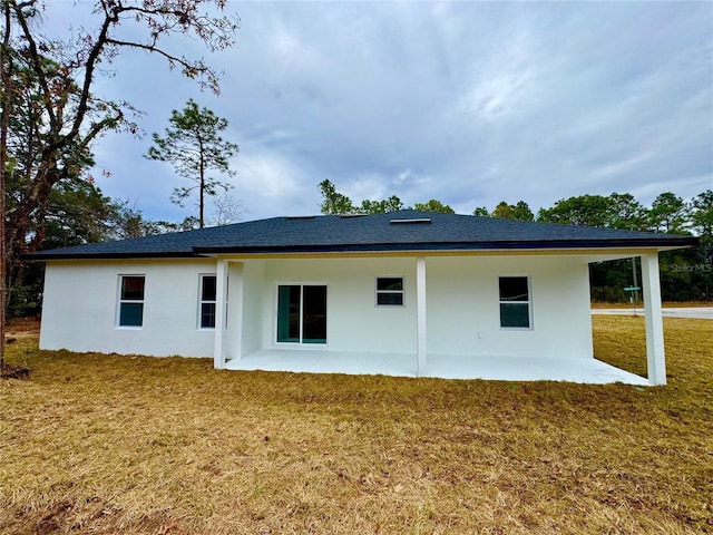 rear view of property featuring a lawn