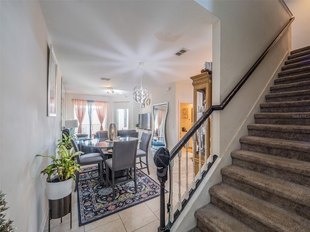 stairway featuring tile patterned floors and a notable chandelier