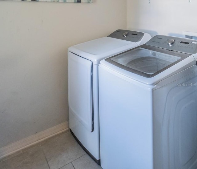 washroom featuring washing machine and dryer and light tile patterned flooring