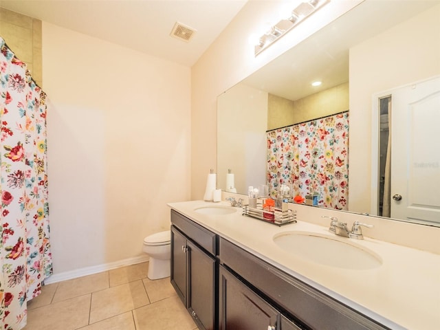 bathroom featuring walk in shower, vanity, toilet, and tile patterned flooring