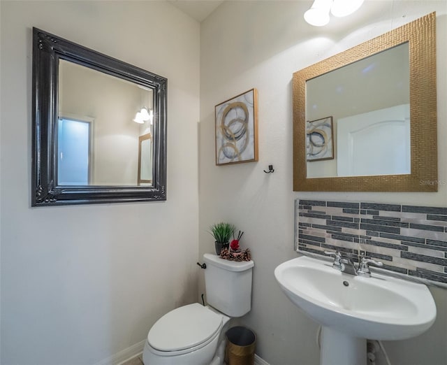 bathroom featuring tasteful backsplash, sink, and toilet