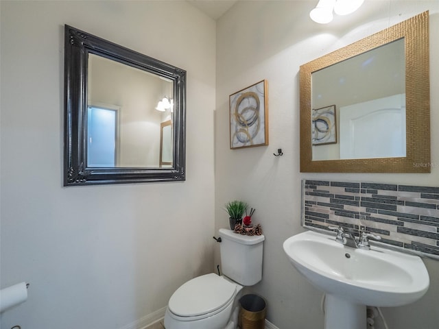 bathroom with tasteful backsplash, sink, and toilet