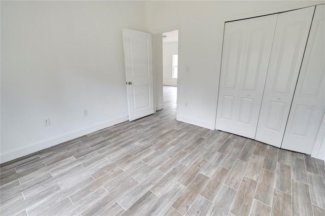 unfurnished bedroom with light hardwood / wood-style floors and a closet