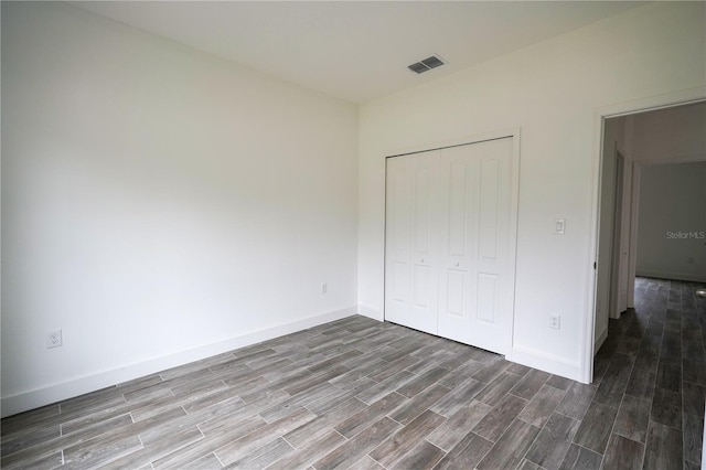 unfurnished bedroom featuring hardwood / wood-style floors and a closet