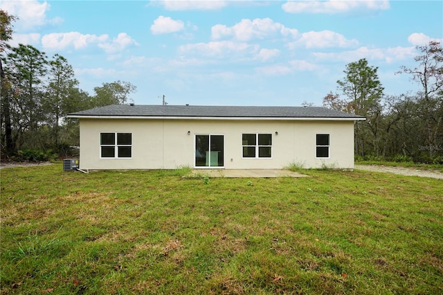 rear view of property with cooling unit, a patio, and a lawn