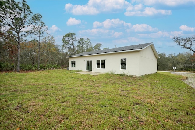 rear view of property featuring a patio area and a yard