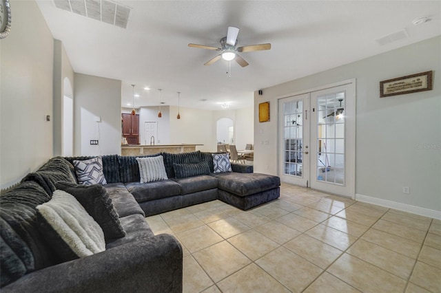 living room featuring light tile patterned floors, sink, french doors, and ceiling fan