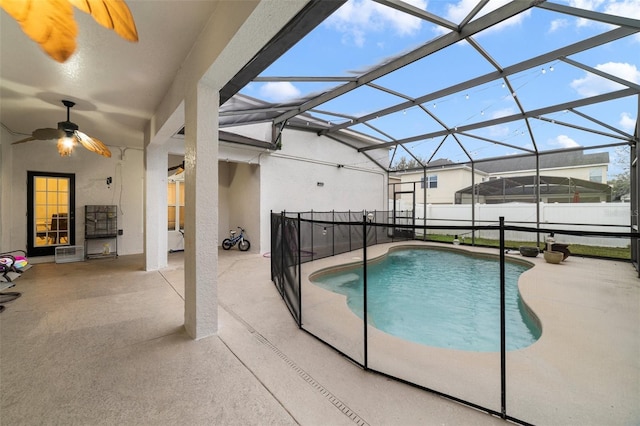 view of swimming pool featuring ceiling fan, a lanai, and a patio