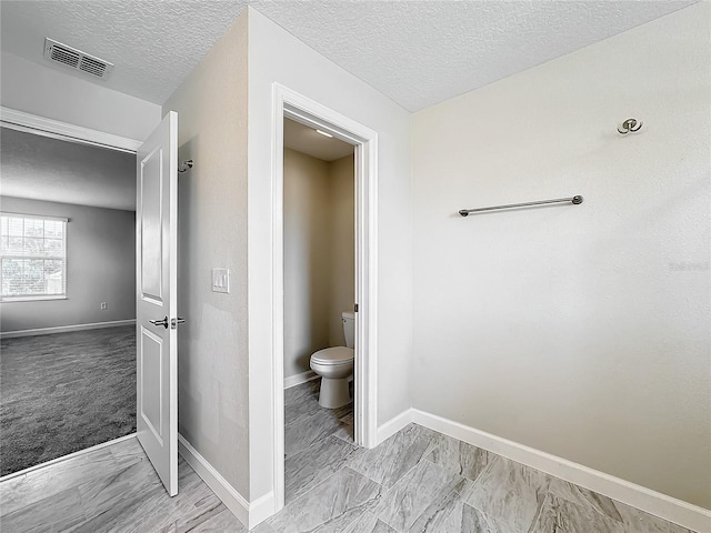 bathroom featuring a textured ceiling and toilet