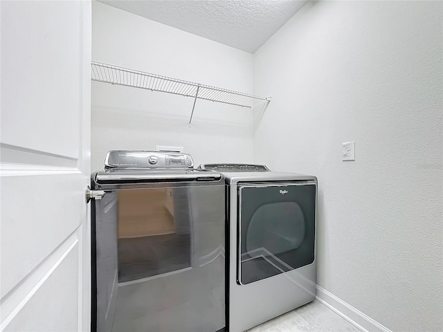 laundry area featuring separate washer and dryer and a textured ceiling