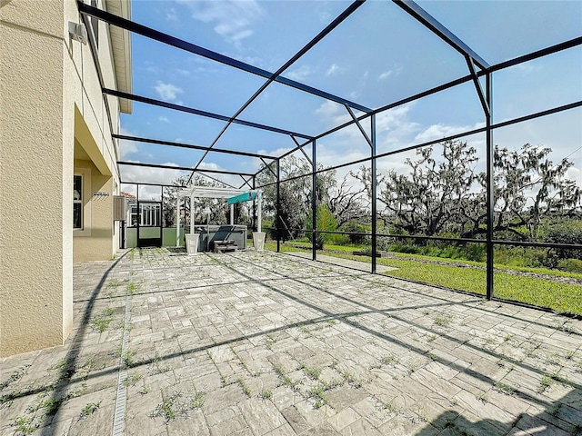 view of patio / terrace with a hot tub and glass enclosure