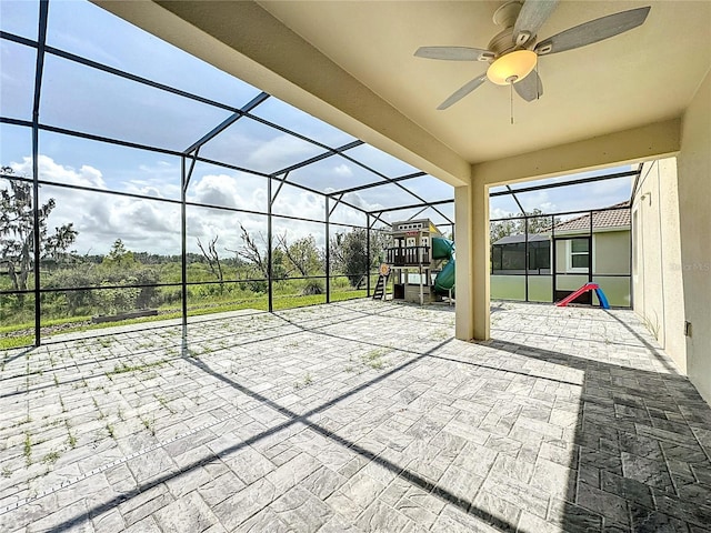 view of patio featuring ceiling fan, a lanai, and a playground