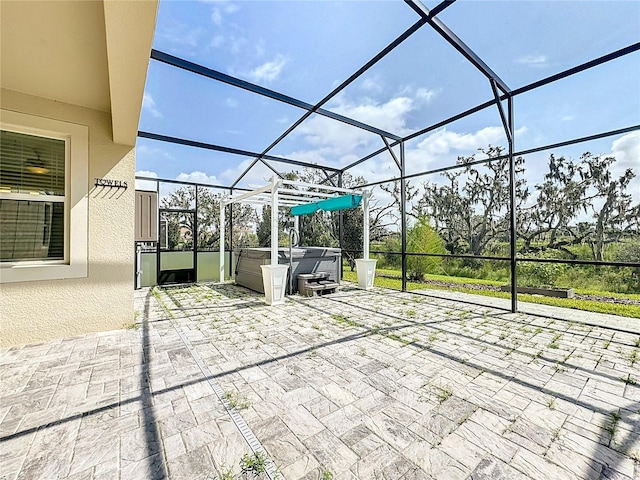 view of patio featuring a hot tub and a lanai