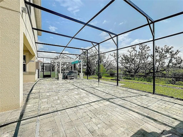 view of patio featuring a lanai and a hot tub