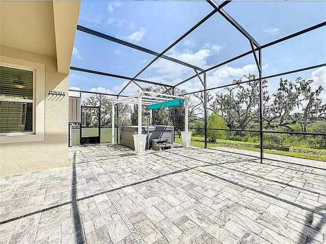 view of patio featuring a lanai and a hot tub