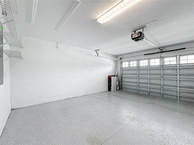 garage with concrete block wall and a garage door opener