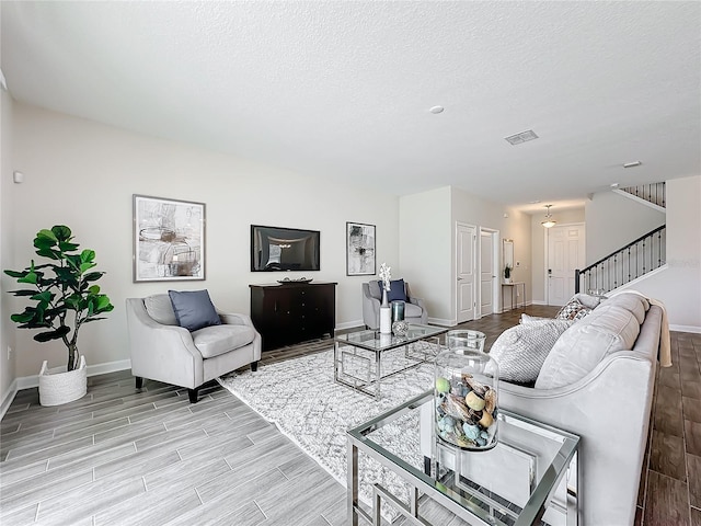 8886 Fallen Oak Dr, Davenport, FL 33896 - living area with light wood finished floors, stairs, and a textured ceiling