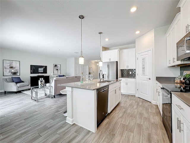 8886 Fallen Oak Dr, Davenport, FL 33896 - kitchen with appliances with stainless steel finishes, open floor plan, light wood-style flooring, white cabinetry, and recessed lighting