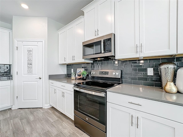 8886 Fallen Oak Dr, Davenport, FL 33896 - kitchen with appliances with stainless steel finishes, tasteful backsplash, white cabinetry, and recessed lighting