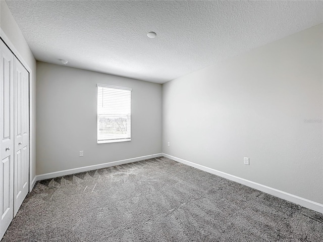 8886 Fallen Oak Dr, Davenport, FL 33896 - unfurnished bedroom featuring carpet flooring, a closet, and a textured ceiling