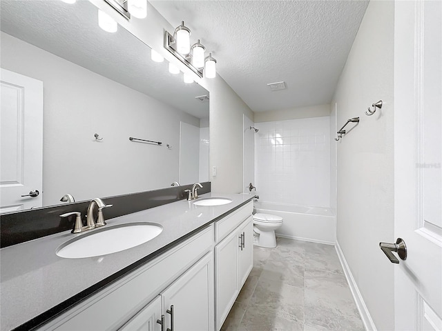 8886 Fallen Oak Dr, Davenport, FL 33896 - bathroom featuring double vanity, a textured ceiling, shower / washtub combination, and marble look tiles