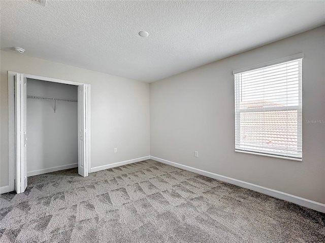 8886 Fallen Oak Dr, Davenport, FL 33896 - unfurnished bedroom featuring a textured ceiling, carpet, and a closet