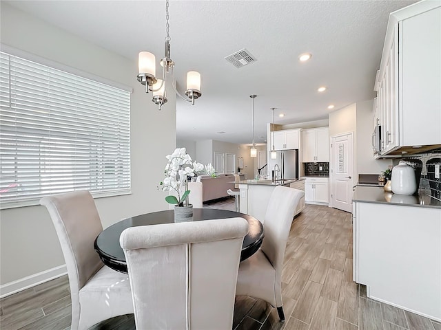 8886 Fallen Oak Dr, Davenport, FL 33896 - dining space featuring wood finish floors, a chandelier, and recessed lighting