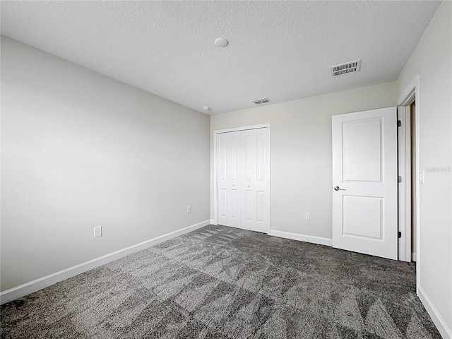 8886 Fallen Oak Dr, Davenport, FL 33896 - unfurnished bedroom with carpet, a textured ceiling, and a closet