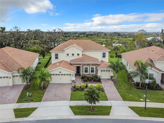 8886 Fallen Oak Dr, Davenport, FL 33896 - mediterranean / spanish house with a tile roof, a front yard, driveway, and stone siding
