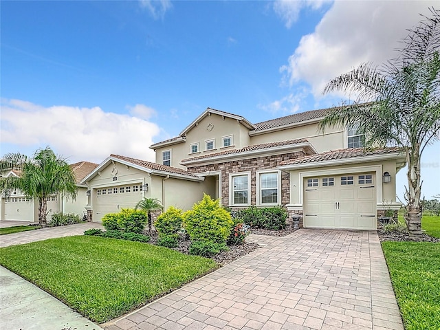 8886 Fallen Oak Dr, Davenport, FL 33896 - view of front of home with decorative driveway, an attached garage, stucco siding, stone siding, and a front lawn