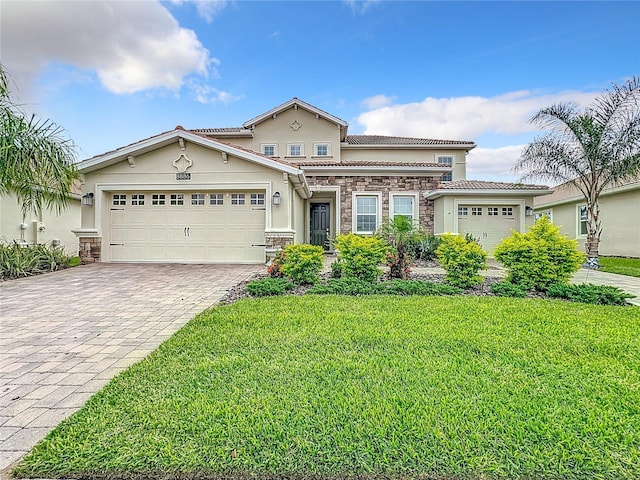 8886 Fallen Oak Dr, Davenport, FL 33896 - view of front facade featuring stucco siding, stone siding, decorative driveway, a front lawn, and an attached garage